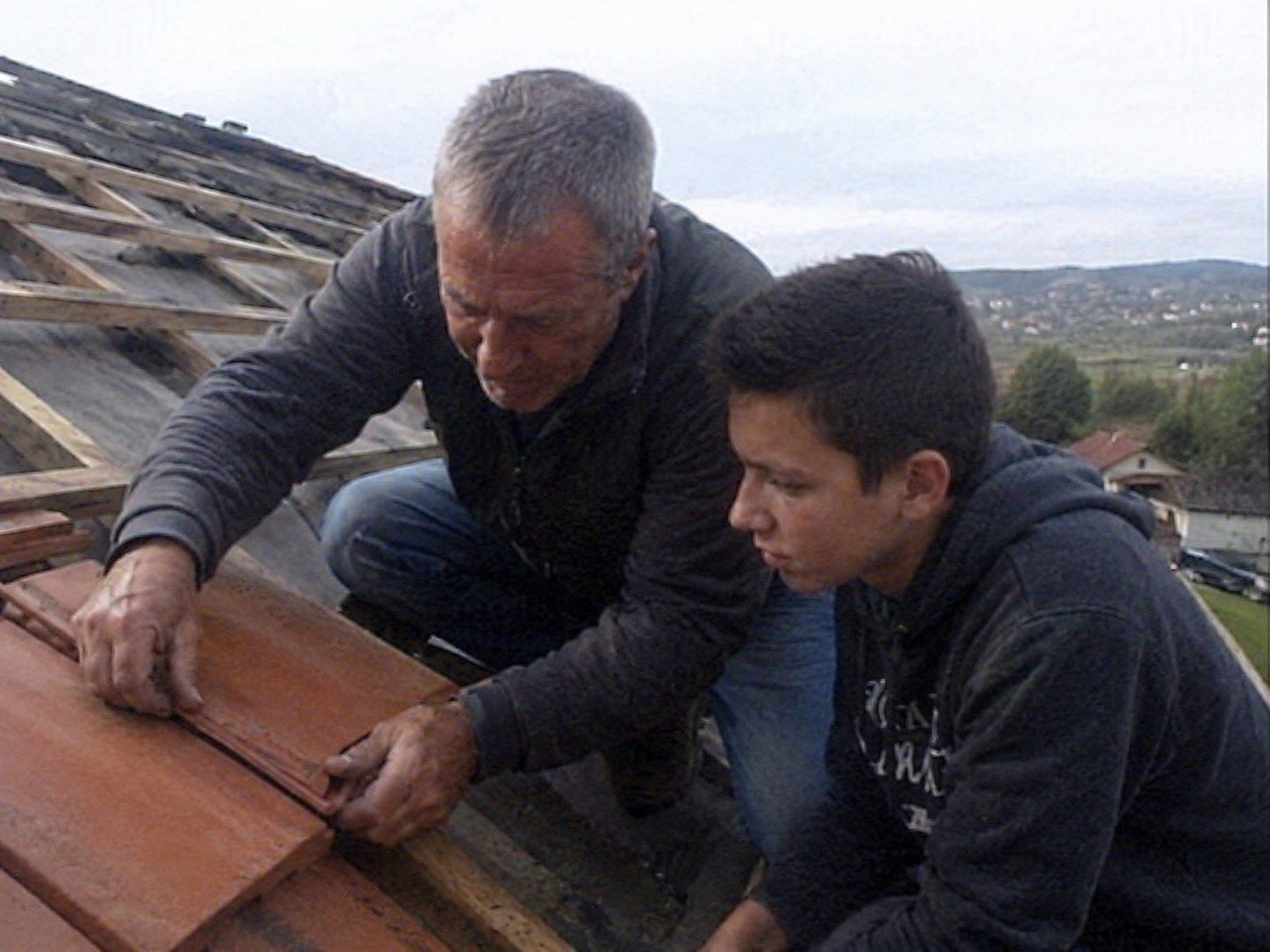 Transmission familiale — grand-père et petit-fils couvreurs